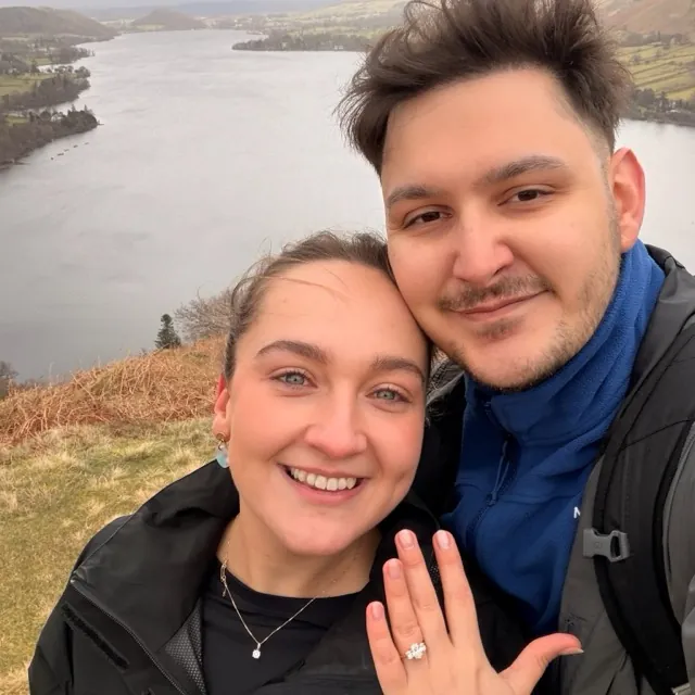 Benjamin and Danielle showing off the engagement ring above a lake